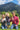Three people outdoors with a mountain in the background, holding bottles.